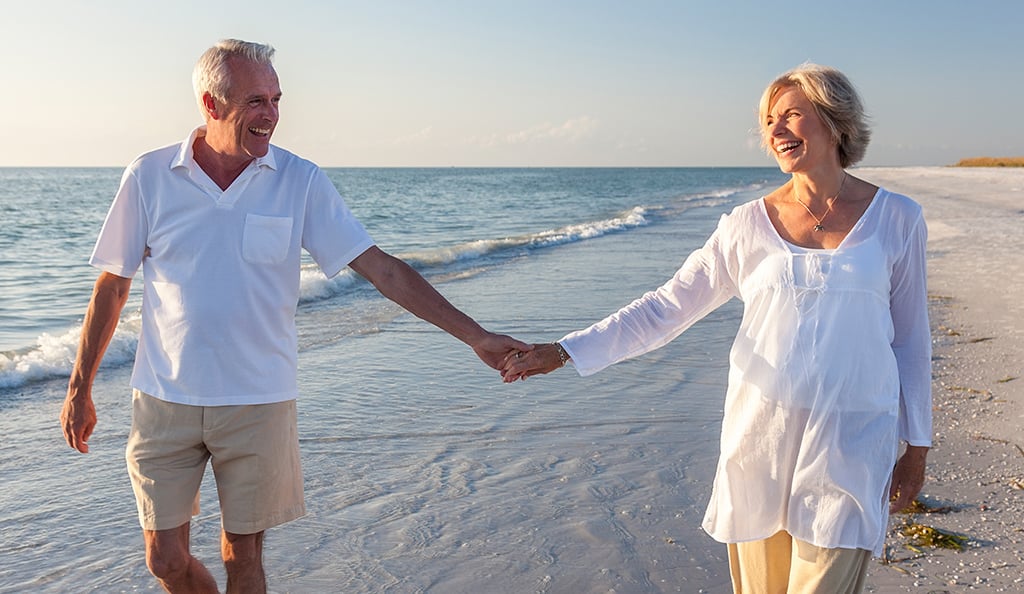 Couple walking hand-in-hand at the beach